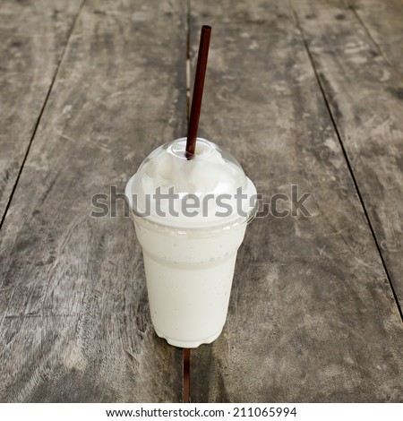 Fresh milk shake drink on wooden table.
