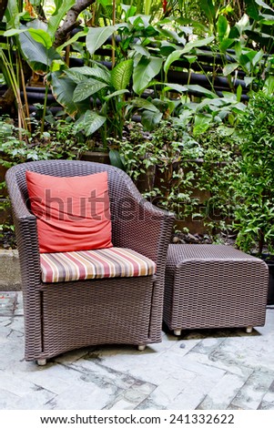 Rattan chair and rattan coffee table with green trees at outdoor