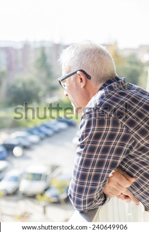 adult man looking out the balcony to the horizon