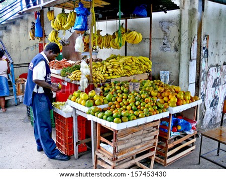 PANAMA CITY, PANAMA, DECEMBER 20 2006.  A coloured man peeling a fruit in front of a fruit selling stand, in Panama City, on December 20th 2006. FOR EDITORIAL USE ONLY.