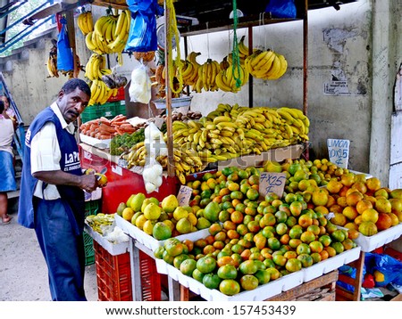 PANAMA CITY, PANAMA, DECEMBER 20 2006.  A coloured man peeling a fruit in front of a fruit selling stand, in Panama City, on December 20th 2006. FOR EDITORIAL USE ONLY.
