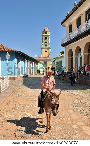 TRINIDAD, CUBA, OCTOBER 27, 2009. An old man sitting on the back of a donkey, in Trinidad, Cuba, on October 27th, 2009.