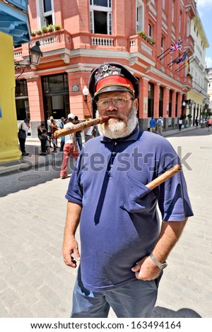 HAVANA, CUBA, MAY 6, 2009. An old man standing on a street with a sailor\'s hat and a huge cigar in Havana, Cuba, on May 7th, 2009.