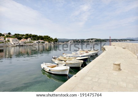 A small dock with white boats in the shore of a small lake with turquoise water in Croatia, on May 23rd, 2011.
