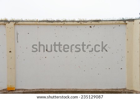 A barricade wall covered with broken glass to prevent intruders.