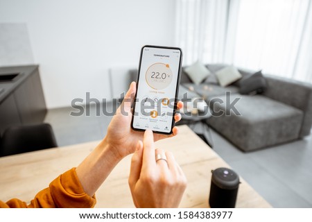Controlling home heating temperature with a smart home, close-up on phone. Concept of a smart home and mobile application for managing smart devices at home Stock foto © 
