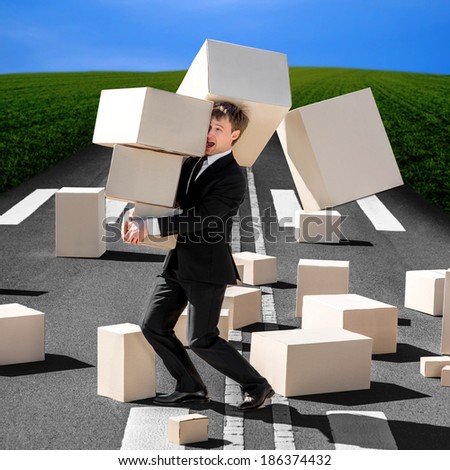 Shocked business man carrying carton boxes that fall down to the road