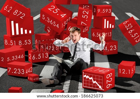 businessman broker shocked about collapse of shares on the stock exchange sitting with laptop on the asphalt surrounded by red boxes
