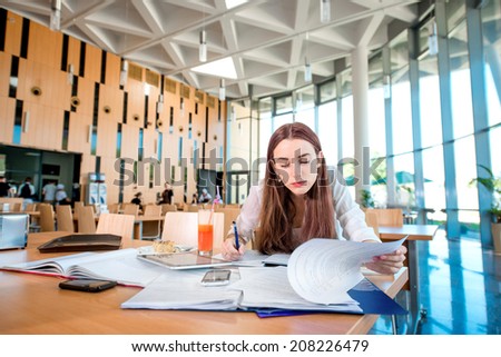 Girl studying in the University canteen with Fresh and cake