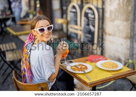 Woman eating italian pasta and drinking wine at restaurant on the street in Rome. Concept of Italian gastronomy and travel. Stylish woman with sunglasses and colorful hair shawl Stock fotó © 
