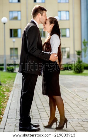 Young business couple kissing outdoor near the office building