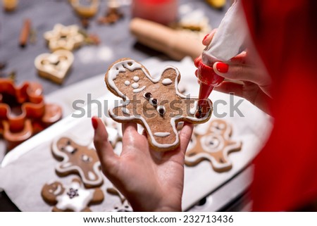 Making ginger cookie on Christmas decorated table on festive lighting background