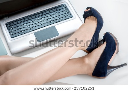 Woman legs with heels on the office table