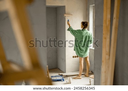 Woman painting wall on street
