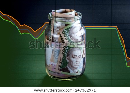 Ukrainian five hundred banknots in the jar with exchange rate schedule on black background