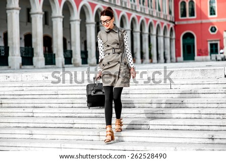 Young woman walking with travel bag down stairs at the Republic square in Split city