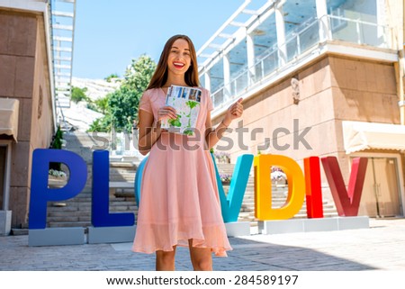 Woman with travel map on colorful letters background in Plovdiv, european cultural capital 2019
