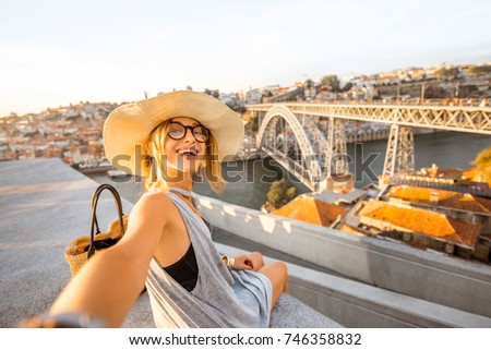 Foto Bild Frau in Porto Brücke, die Bilder mit Kamera bei Sonnenuntergang. Tourismus in der Stadt Europa. Reisen