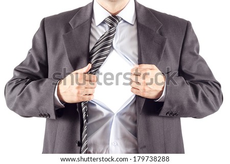 Businessman in classic superman pose tearing his shirt open to reveal blank copy space on chest