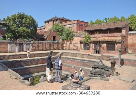 Bhaktapur, Nepal, October, 26, 2012, Nepali  Scene: People walking near ancient well on Durbar square.  In may 2015 square partially destroyed during the earthquake