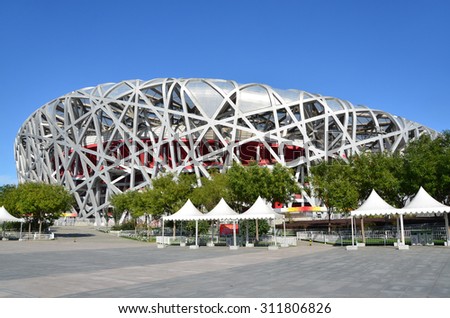 Beijing, China, October, 10, 2012. People walking near Bird\'s Nest in autumn day. The Bird\'s Nest is a stadium in Beijing, especially designed for use throughout the 2008 Summer Olympics Games