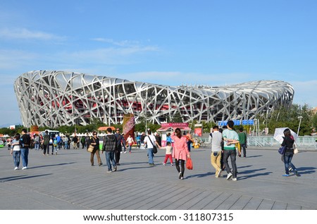 Beijing, China, October, 10, 2012. People walking near Bird\'s Nest in autumn day. The Bird\'s Nest is a stadium in Beijing, especially designed for use throughout the 2008 Summer Olympics Games