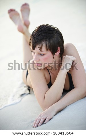 Yang and beautiful woman lying down on the beach.