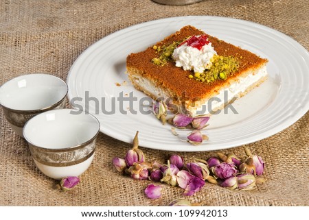 Plate of Arabic oriental sweets next to two small cups.