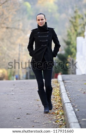 Yang pretty woman walks alone on Autumn road.