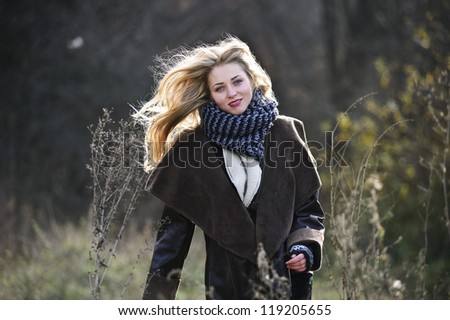 Portrait of yang and cute blond girl in late Autumn field.