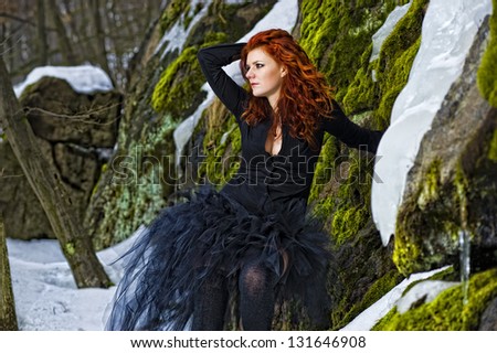 Portrait beautiful red haired woman in winter forest.