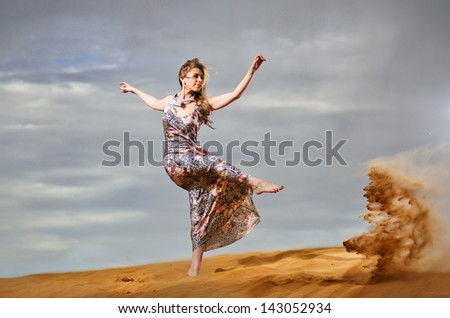 Yang and beautiful European woman having fun in yellow desert.