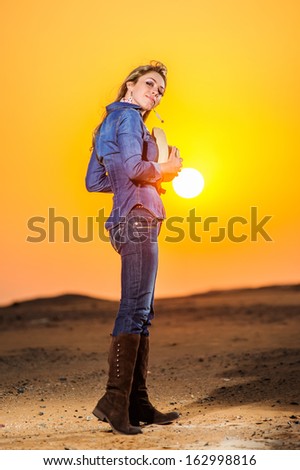 Portrait of beautiful country girl in front of red sunset.