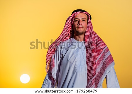 Portrait of Middle Eastern Arab man in desert on sunset time.