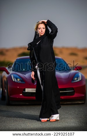 Women dressed middle eastern way poses on sunset.