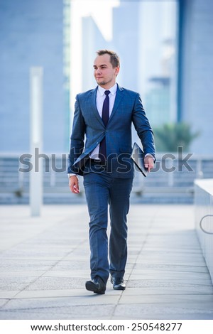 Portrait of yang businessman in suit outdoors.Walking man.