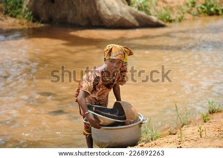 BANDIAGARA, MALI, AFRICA - AUGUST, 28, 2011 Girl doing heavy work tasks in the river
