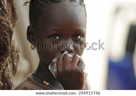 Mopti, Mali, Africa. August, 26, 2011: Mopti girl drinks water from a plastic bag