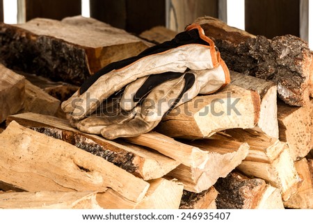 Dirty work gloves on a stack of chopped wood