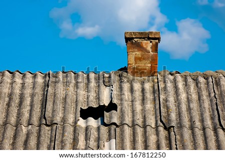Old damaged roof with chimney