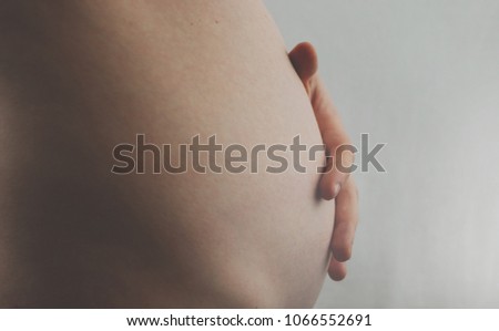 Pregnant Woman Belly. Pregnancy Concept. The third or fourth month. Second trimester. Pregnant tummy close up 商業照片 © 