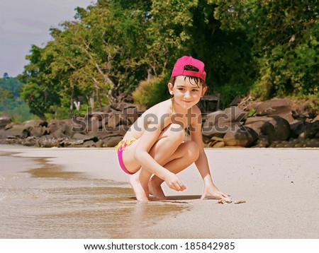 Beach tropical vacation caucasian kid girl with playing at the sand