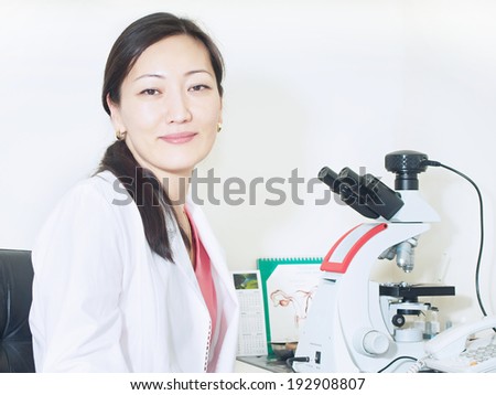 Portrait of young asian girl doctor gynecologist with microscope in laboratory