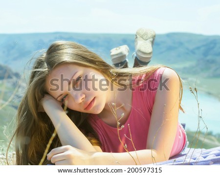 Portrait of young caucasian beautiful sport women lying on travel mat  in summer nature on the background of river