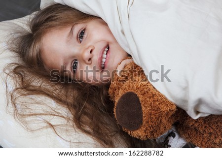 pretty little girl with toy in bed