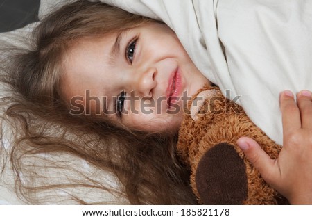 pretty little girl with toy in bed