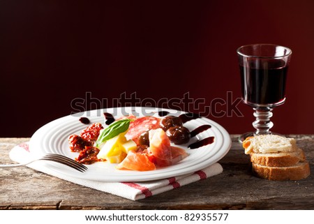 mixed italian antipasti on a plate with wine