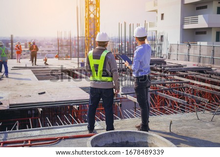 Structural engineer and foreman worker with touch pad discuss, plan working for the outdoors building construction site. Foto stock © 