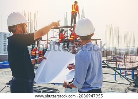 Structural engineer and foreman worker with blueprints discuss, plan inspecting for the outdoors building construction site. Foto stock © 