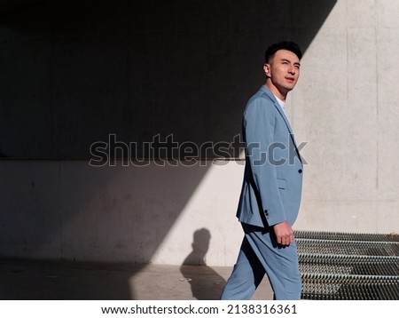 Similar – Image, Stock Photo Confident Asian man walking along city street